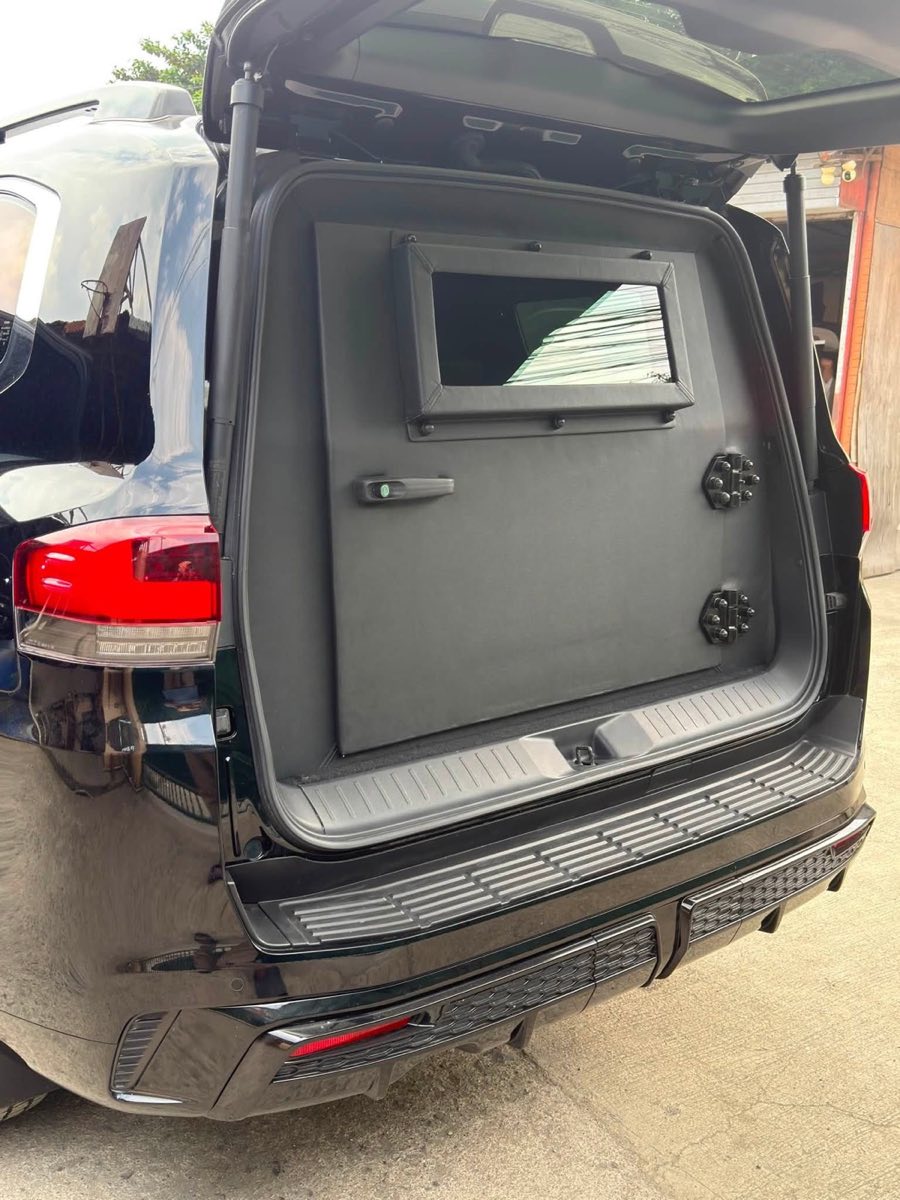 Open armored rear door on a Toyota Land Cruiser 200 showing the ballistic panel