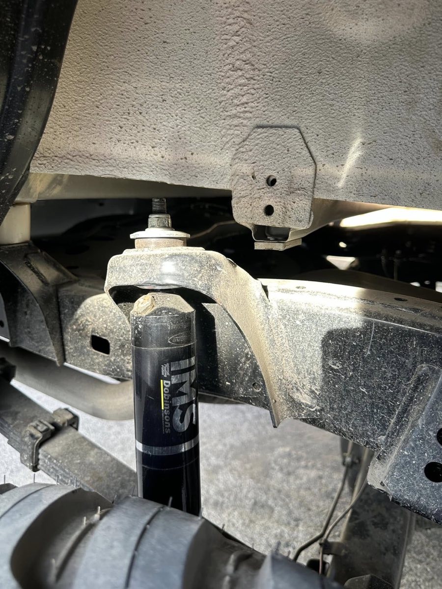 Upgraded heavy-duty suspension components fitted under an armored vehicle